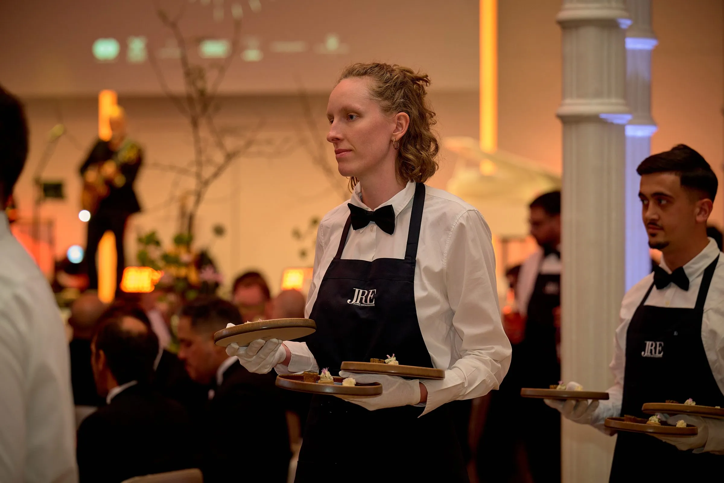 Kellnerin mit Tablett im Ballsaal