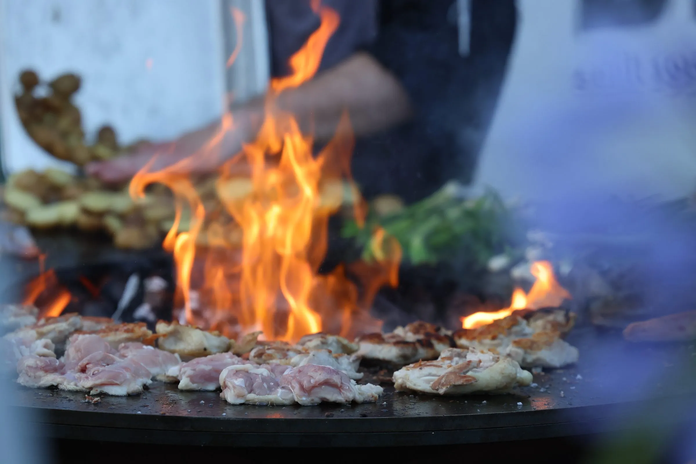 Koch am offenen Feuer beim BBQ-Catering